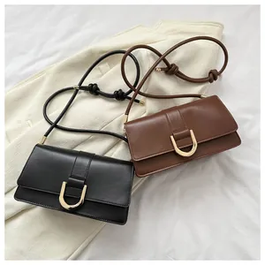 Top view of sleek black and brown leather baguette bags with gold U-shaped metal buckles