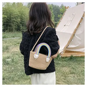 Detailaufnahme der khakifarbenen Strohtasche mit bunten Regenbogen-Griffen für den Sommer