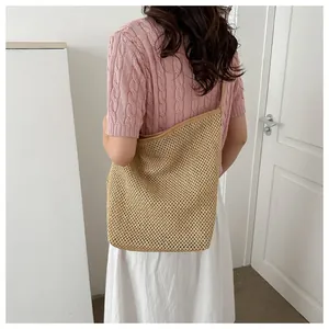 Détail de la texture tissée ajourée et du tissu en paille beige naturel du sac cabas
