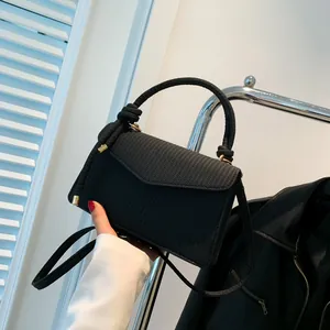 Fashionable black corduroy crossbody bag with woven texture and gold buckle design