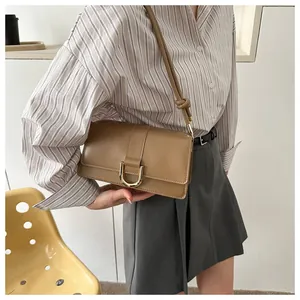 Close-up of a light brown vintage bag with a golden horseshoe buckle and leather texture