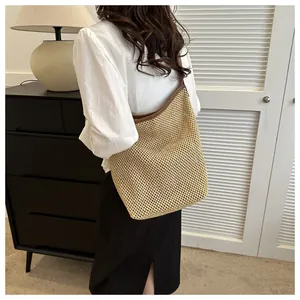 Détail du grand sac cabas en paille tissée avec bordure en cuir marron et style bohème