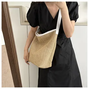 Détail du sac cabas en paille tissée avec bordure en cuir blanc et maille ajourée