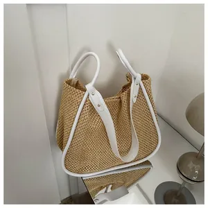 Dettaglio della borsa tote in paglia intrecciata con finiture in pelle bianca e rivetti
