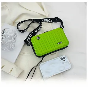 Detail of lime green mini hardshell crossbody bag with striped suitcase design