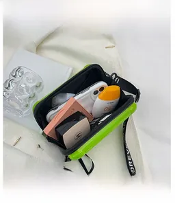 Internal storage view of mini suitcase crossbody bag showing space for phone and makeup