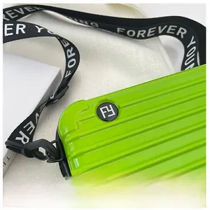 Detail of neon green hard shell suitcase bag with a wide Forever Young branded strap