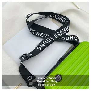 Detail of comfortable black fabric shoulder strap on fluorescent green hardshell suitcase bag