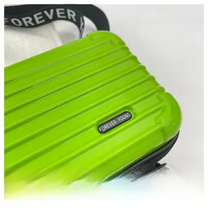 Detail of lime green mini hardshell suitcase bag with vertical grooves and strap