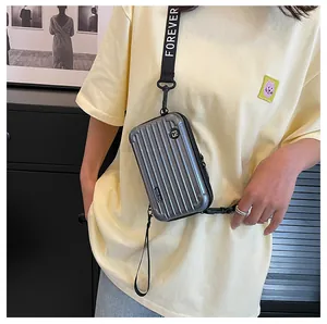 Mini silver hardshell suitcase crossbody bag with Forever Young strap and striped texture