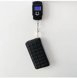Digital scale showing the lightweight 0.135kg mass of this black quilted long wallet