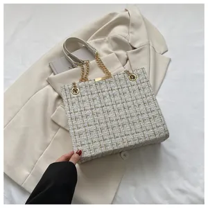 Détail du sac en tweed avec bandoulière en chaîne dorée et boucle carrée dorée