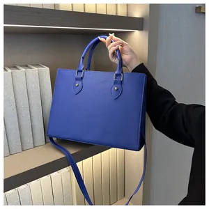 Detail of navy blue large tote bag with cross-pattern leather and gold metal studs