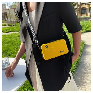 Detail of yellow hardshell mini suitcase bag with vertical ribs and wide letter strap