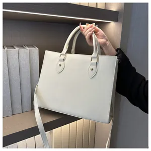 Close-up of cream large tote bag with Saffiano texture and elegant gold hardware