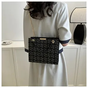 Détail du sac en tweed noir et doré avec texture tissée et bandoulière chaîne