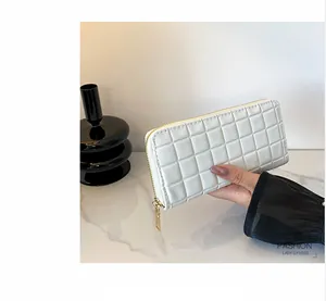 Close-up of white quilted long wallet for women with golden zipper closure and elegant finish