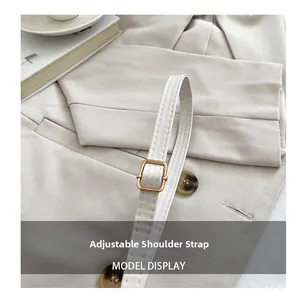 Detail of adjustable shoulder strap with gold metal buckle on a beige square handbag