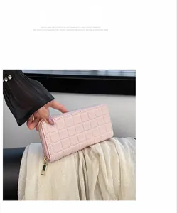 Close-up of pink checkered pattern texture on a long wallet with golden zipper