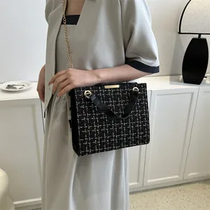 Sac à bandoulière chic en tweed noir et blanc avec chaîne dorée et poignée en cuir
