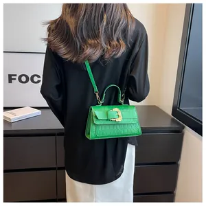 Green crocodile pattern crossbody bag shown from a model perspective on the back