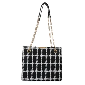 Sac cabas à carreaux noir et blanc chic avec bandoulière chaîne dorée sur fond blanc