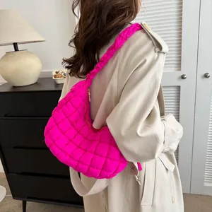 Détail macro du sac nuage matelassé rose vif avec bandoulière froncée sur mannequin