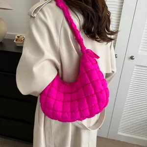 Détail du sac nuage matelassé rose vif avec bandoulière froncée sur un manteau