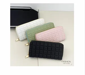 Detail view of quilted checkerboard wallets in white green pink and black with gold zippers