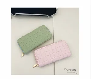 Detail of long quilted women's wallets in pale pink and green with gold zipper hardware
