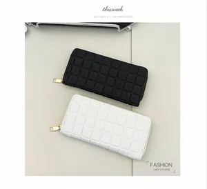 Flat lay of black and white checkered leather long wallets with golden zippers
