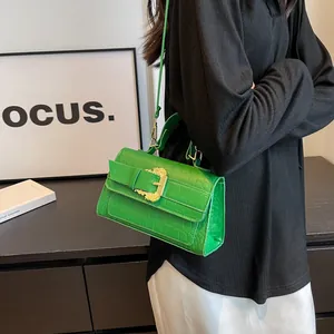 Bright green crocodile pattern crossbody bag with gold embossed buckle detail