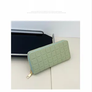Close-up of light green quilted faux leather wallet with premium gold zipper detail