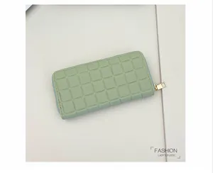Close-up of mint green long wallet with checkered texture and golden zip hardware