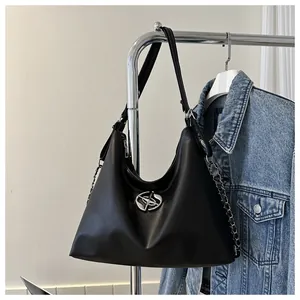 Detail of black leather hobo bag featuring silver star hardware and chain strap accents