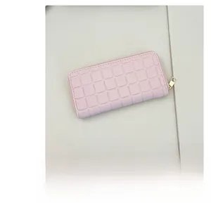 Macro detail of pink checkered quilted pattern on long women's wallet with gold zipper