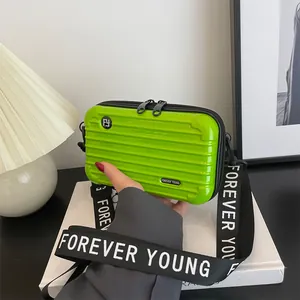 Neon green mini suitcase crossbody bag with Forever Young strap and hardshell design