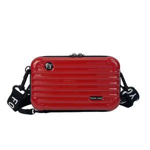 Mini red suitcase shaped crossbody bag with hardshell finish and wide nylon shoulder strap