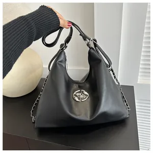 Detail of black PU leather hobo bag with silver logo hardware and chain strap