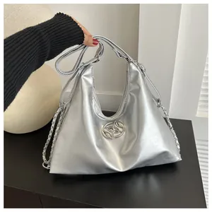 Detail of silver metallic hobo bag with leather chain strap and round metal buckle logo
