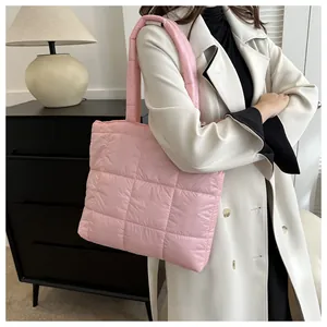 Detail of pink quilted puffer tote bag showing the large square padded stitch pattern