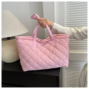 Close-up of pink quilted tote bag showing intricate floral embroidery on diamond patterns