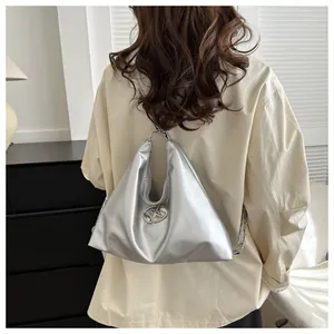 Silver metallic chain backpack for women featuring a high-gloss finish and sleek metal logo