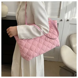 Detail of pink quilted tote bag with soft diamond stitching and long shoulder strap