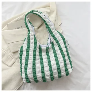 Detail of green and white striped puff shoulder bag with textured seersucker fabric