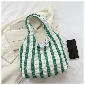 Close-up of green and white striped puff tote bag with unique bubble textured fabric