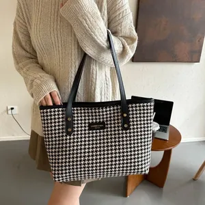 Large houndstooth tote bag with black leather straps and gold rivets for daily commute