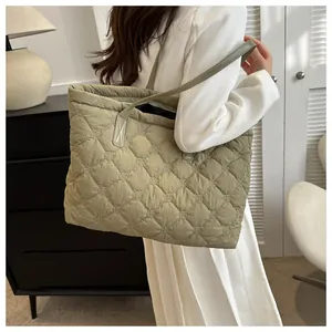 Detailed close-up of large quilted puffer tote bag in sage green with diamond stitch patterns