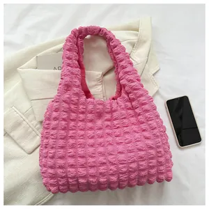 Detailed close-up of pink puff flower popcorn texture fabric on a stylish tote bag