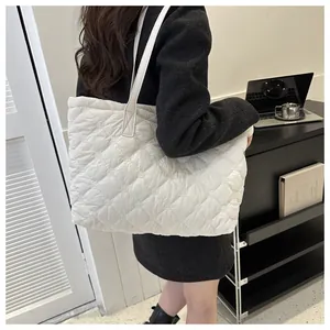 White quilted tote bag with diamond stitching shown from a side-back view on shoulder